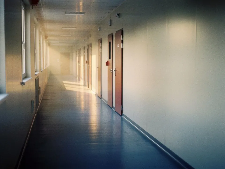 Clean factory dormitory corridor with evenly spaced doors in daylight